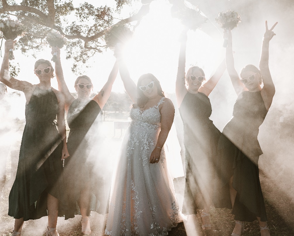 bride and bridesmaids waving bouquets in the air