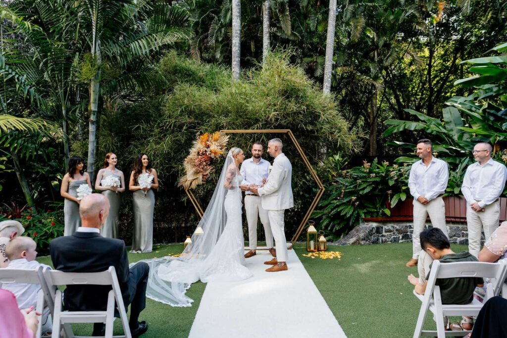 best man with wedding rings presenting them to the bride and groom